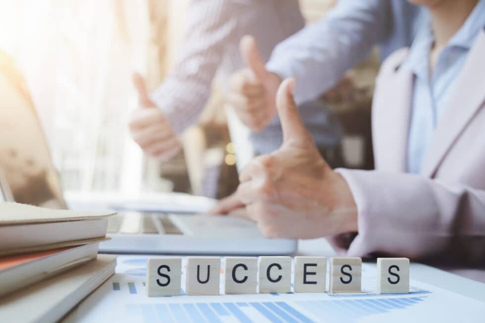“Success” word on business working table. Wooden cross word alphabet “Success”. Business teamwork success concept.